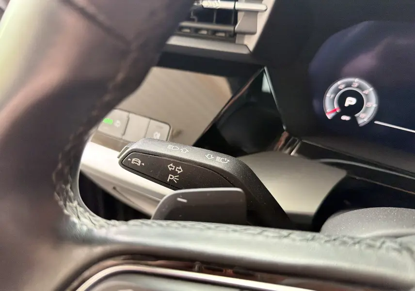 Gros plan sur la manette de clignotant à gauche du volant de l’Audi A3 Sportback 2021, intérieur noir avec tableau de bord digital.