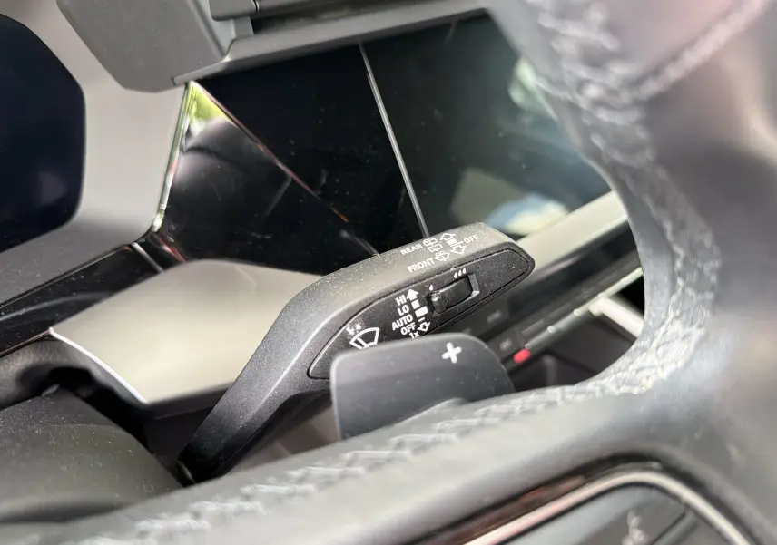 Gros plan sur la commande d’essuie-glace à gauche du volant en cuir perforé d’une Audi A3 Sportback gris Manhattan.