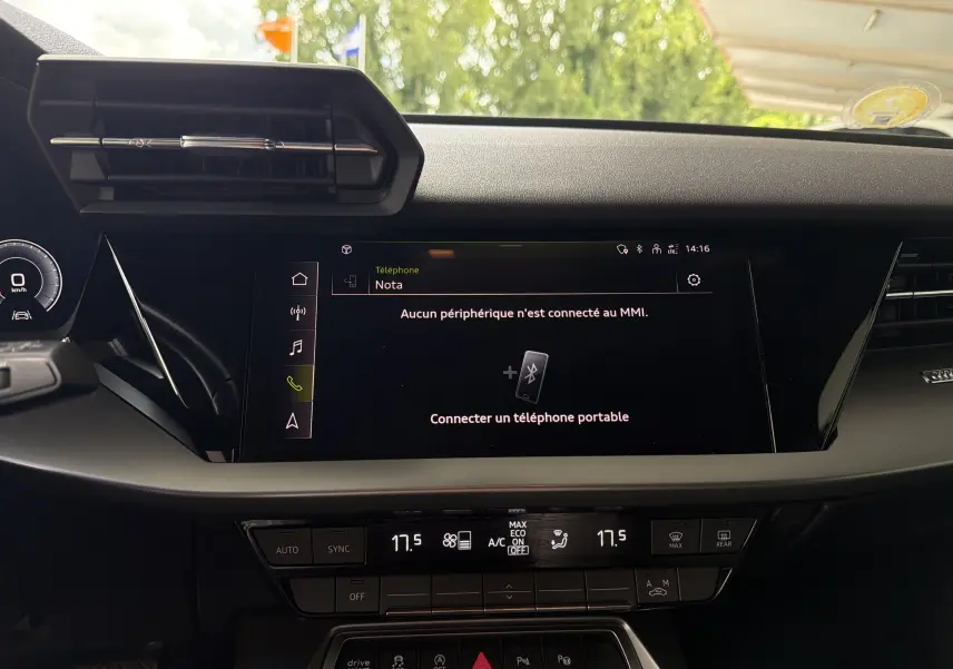 Vue rapprochée du tableau de bord noir de l'Audi A3 Sportback 2021 avec écran tactile central et commandes climatisation.