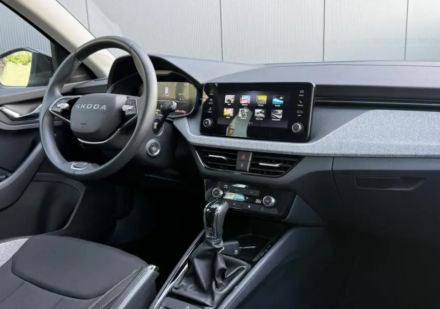 Vue intérieure côté conducteur du Skoda Scala TSI 116 DSG7, volant cuir, écran tactile 8,25 pouces et console centrale noire.