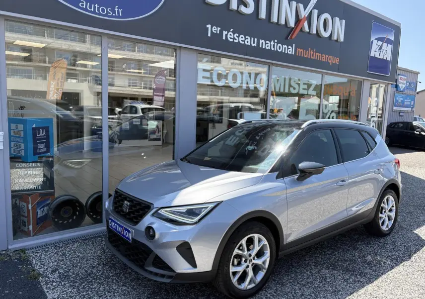 SEAT Arona 2024 gris GRS en 3/4 avant droit, avec jantes alliage 16 pouces et calandre noire satinée.