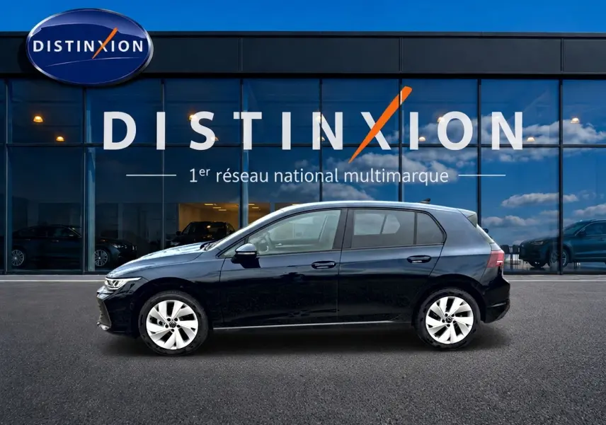 Volkswagen Golf 2026 noire vue de profil côté gauche devant une vitrine avec logo Distinxion.