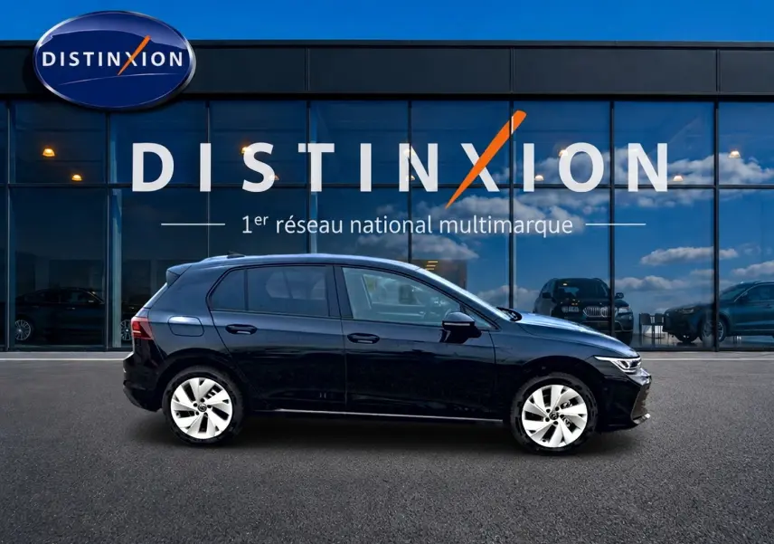 Volkswagen Golf 1.5 ETSI Evo2 noire vue de profil côté gauche devant une vitrine avec logo Distinxion.