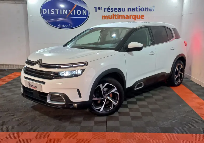 Citroën C5 Aircross blanc en 3/4 avant droit, avec jantes noires et détails noirs contrastants visibles.