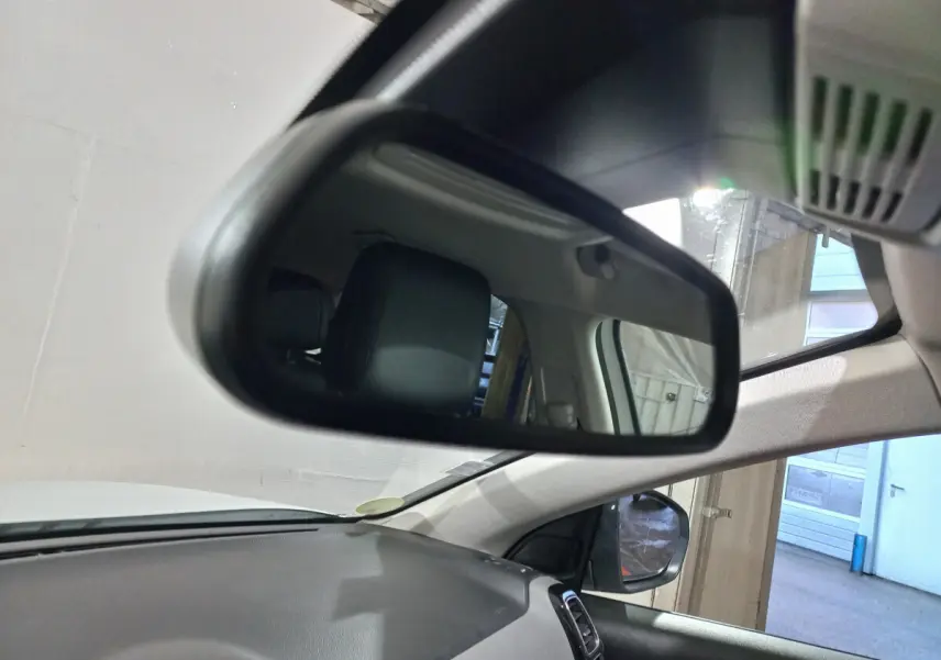 Rétroviseur intérieur montrant l'appui-tête noir côté conducteur du Citroën C5 Aircross blanc, vue depuis l'avant droit.