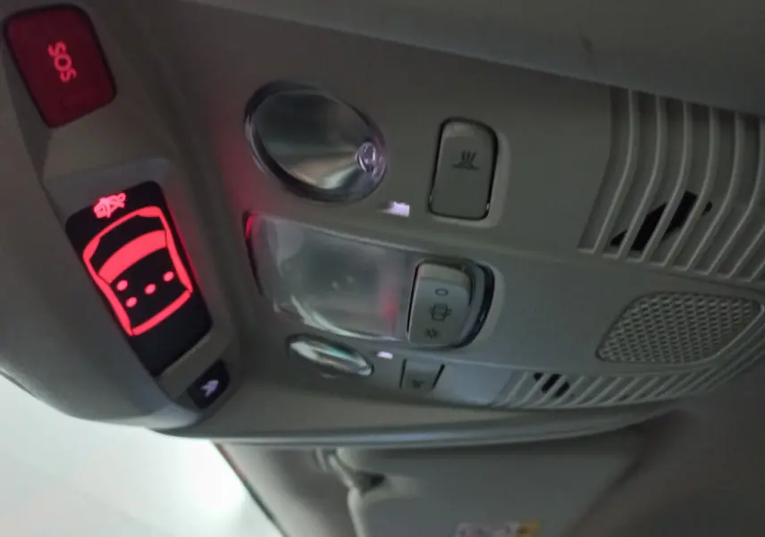Vue en gros plan du plafonnier gris clair du Citroën C5 Aircross avec boutons SOS et éclairage intérieur allumé.