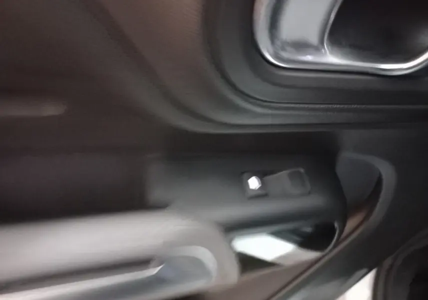 Détail de la poignée intérieure côté gauche d'une Citroën C5 Aircross 2020 avec commandes de vitre noire.