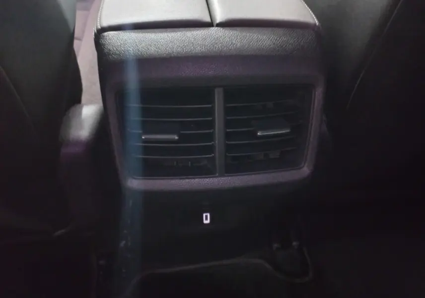 Bouche d'aération arrière noire vue de près entre les sièges arrière d'un Citroën C5 Aircross blanc de 2020