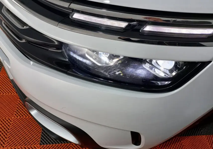 Gros plan sur le phare avant droit blanc du Citroën C5 Aircross 2020 avec éclairage LED et calandre noire.