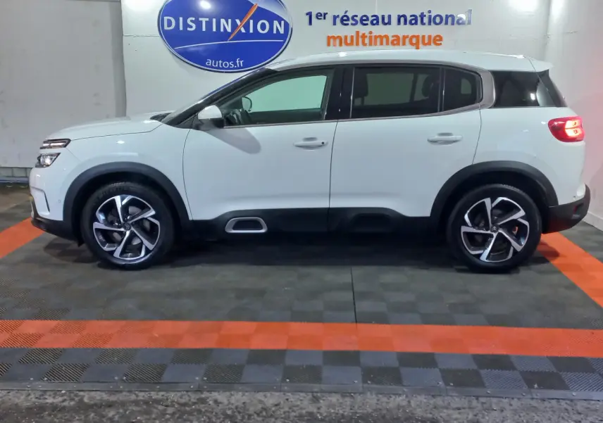 Profil côté gauche d'un Citroën C5 Aircross blanc 2020 avec jantes alliage et protections noires basses.