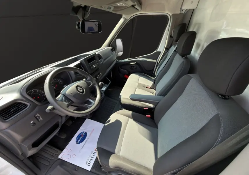 Vue intérieure côté conducteur du Renault Master 2024, montrant le tableau de bord et les sièges gris et noirs.