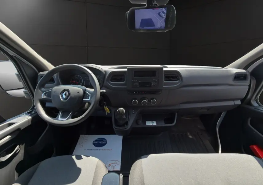 Vue intérieure avant du Renault Master 2024 blanc, tableau de bord simple avec volant, boîte manuelle et écran central.