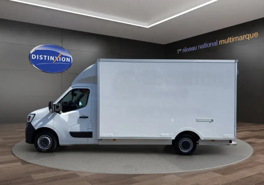 Vue de profil côté gauche d’un Renault Master blanc 2024 avec caisse utilitaire volumineuse en intérieur showroom.