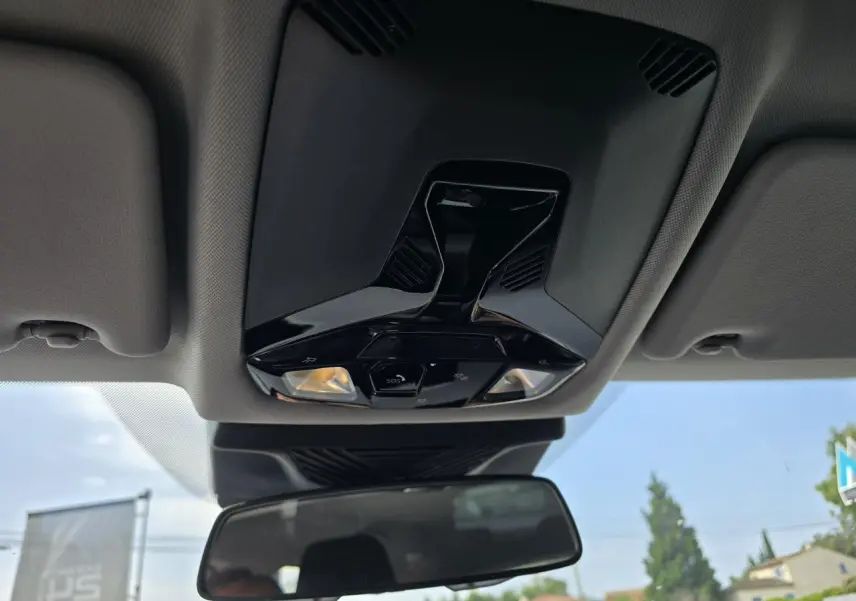 Plafonnier avec commandes et éclairages intégrés au-dessus du rétroviseur intérieur d'une BMW Série 1 gris Skyscraper.