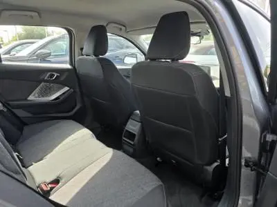 Vue intérieure arrière droite de la BMW Série 1 120D M Sport 2024 avec sellerie tissu anthracite et habillage gris Skyscraper