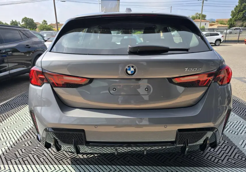 Vue arrière d'une BMW Série 1 120d gris Skyscraper avec feux LED et diffuseur noir M Sport visible.