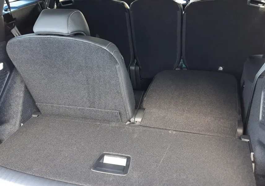 Vue arrière du coffre du Peugeot 5008 bleu Ingaro, siège arrière droit rabattue, intérieur spacieux et modulable.