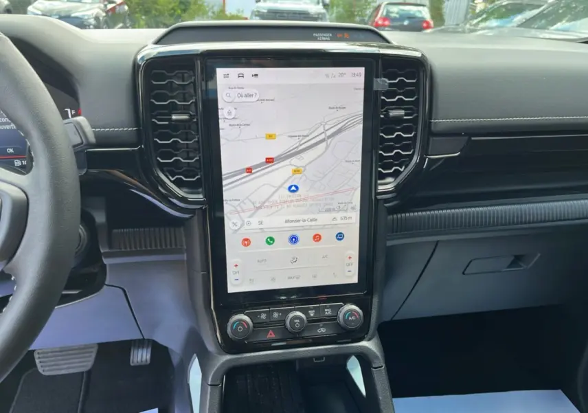 Vue intérieure centrée sur la console centrale tactile verticale du Ford Ranger 2.3 PHEV avec volant partiel visible à gauche.