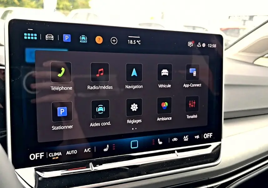 Écran tactile central de la Volkswagen Golf 1.5 noir, vue rapprochée du tableau de bord avec interface multimédia affichée.