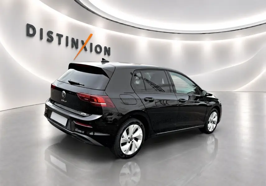 Volkswagen Golf noir vue 3/4 arrière droit en intérieur avec jantes alu 17 pouces et feux arrière LED.