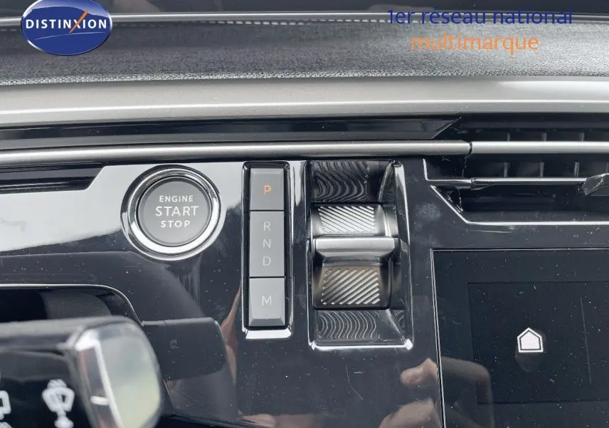 Gros plan sur la console centrale du Peugeot 5008 gris titane avec boutons de boîte auto et bouton start/stop.