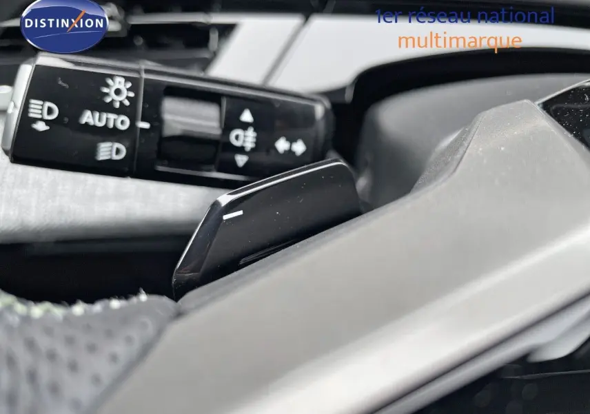 Gros plan sur la commande des feux et le levier de vitesses au volant du Peugeot 5008 Hybrid gris titane toit noir 2025.