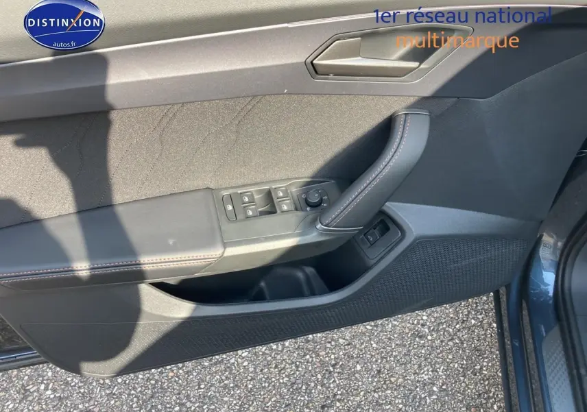 Vue du panneau de porte avant gauche gris magnétique du CUPRA Formentor 1.5 etsi hybrid avec commandes de vitres et rétroviseurs.