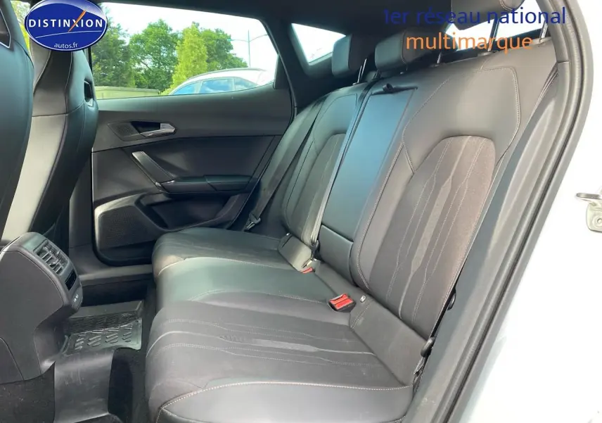 Vue intérieure côté droit montrant la banquette arrière en tissu et similicuir noir avec surpiqûres cuivre du CUPRA Formentor blanc.