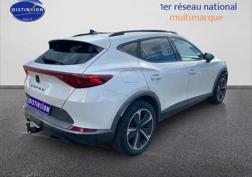 Vue 3/4 arrière droite d'un CUPRA Formentor blanc 2023 avec jantes alu noires et attelage visible.