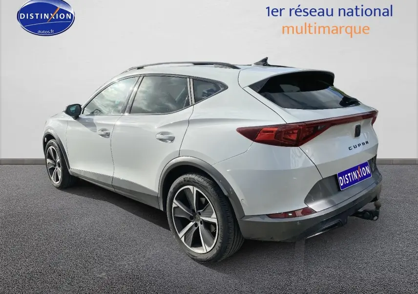 Vue 3/4 arrière droite d'un CUPRA Formentor blanc 2023 avec jantes alu et attelage visible.