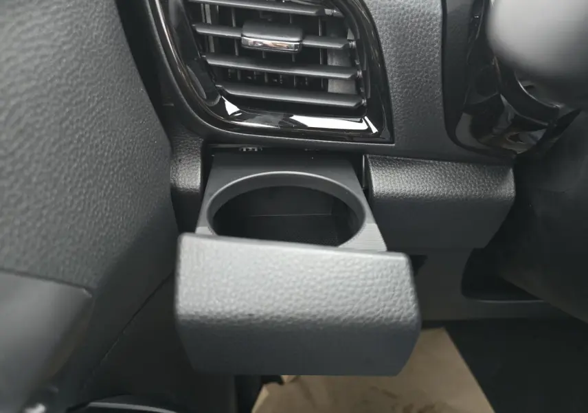 Gros plan sur le porte-gobelet noir déployé à gauche du tableau de bord du pick-up Isuzu D-MAX 2025.