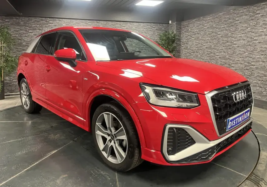 Audi Q2 rouge métallisé vue 3/4 avant droit avec jantes sport 5 branches et calandre noire distinctive