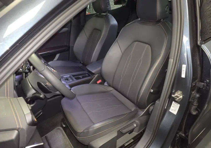 Vue intérieure côté conducteur du CUPRA Formentor gris 2025, sièges sports bimatière noir avec surpiqûres cuivrées.