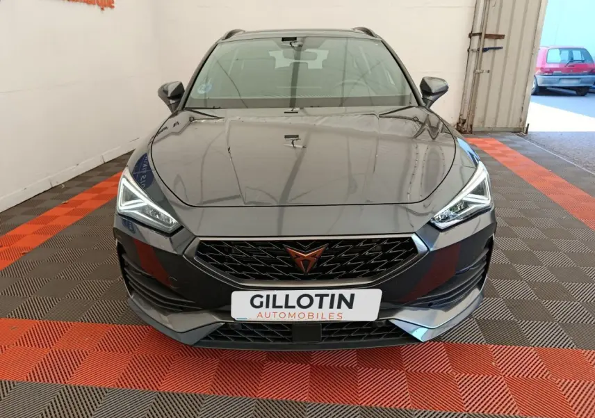 Vue frontale d'une CUPRA LEON ST 1.5 eTSI gris foncé avec phares LED et calandre noire distinctive.
