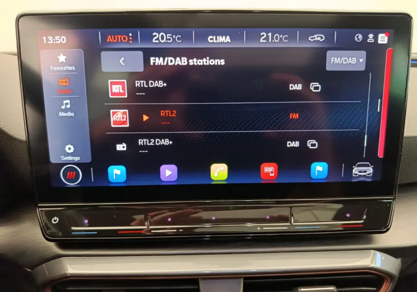 Écran tactile central de 12 pouces affichant les stations radio dans l'habitacle du CUPRA LEON ST gris foncé 2024.