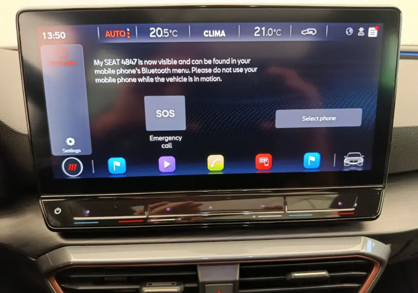 Écran tactile central 12 pouces du tableau de bord de la CUPRA LEON ST 2024 affichant les commandes climatiques et d'appel d'urgence.