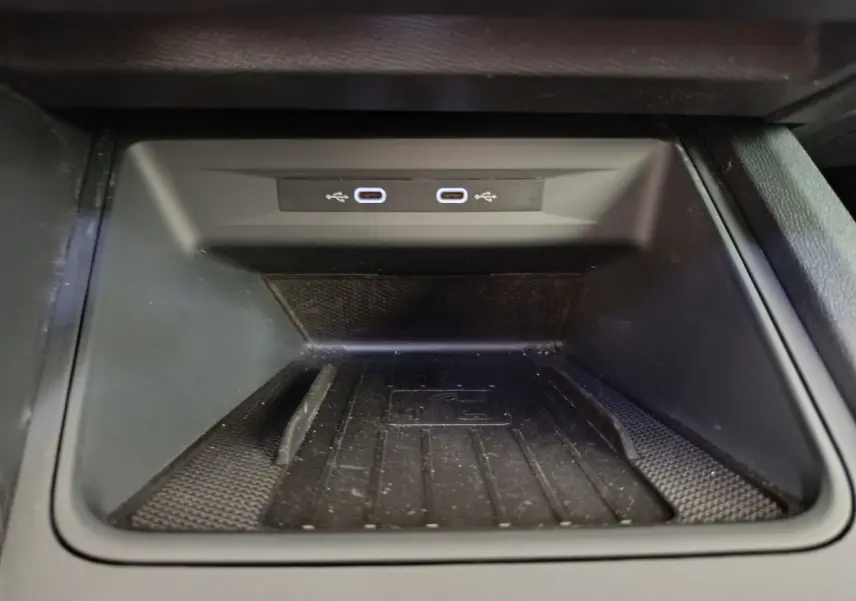 Gros plan sur la zone de recharge par induction avec deux ports USB-C dans la console centrale d'une CUPRA LEON ST gris foncé.