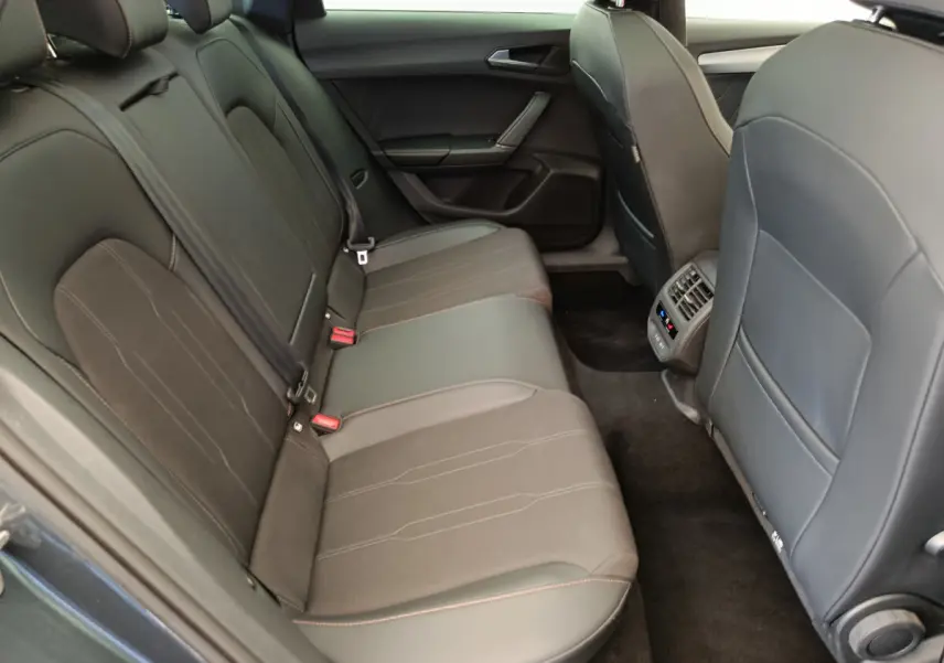 Vue intérieure côté droit des sièges arrière en cuir noir du CUPRA LEON ST 1.5 eTSI 2024 avec console de climatisation arrière.