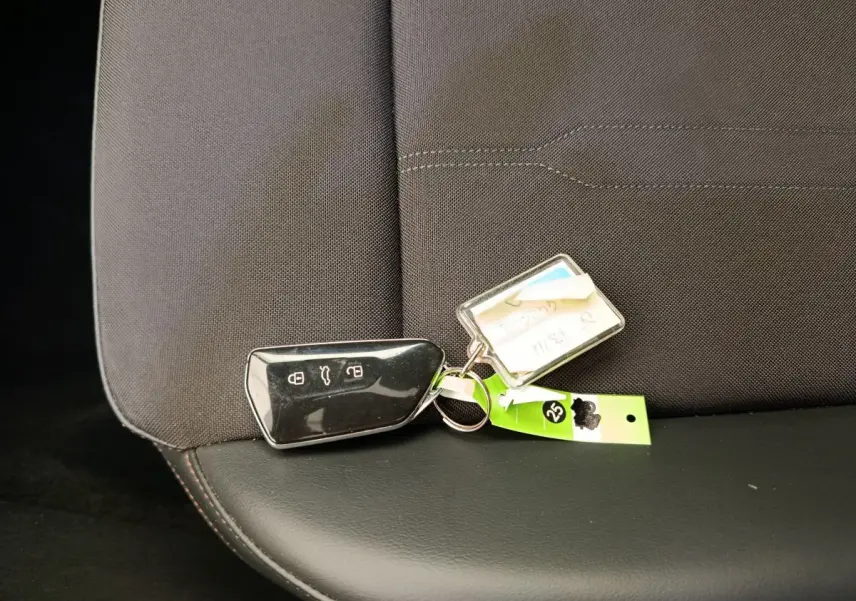 Télécommande noire posée sur la banquette arrière en tissu gris foncé et cuir noir d'une CUPRA LEON ST 2024.