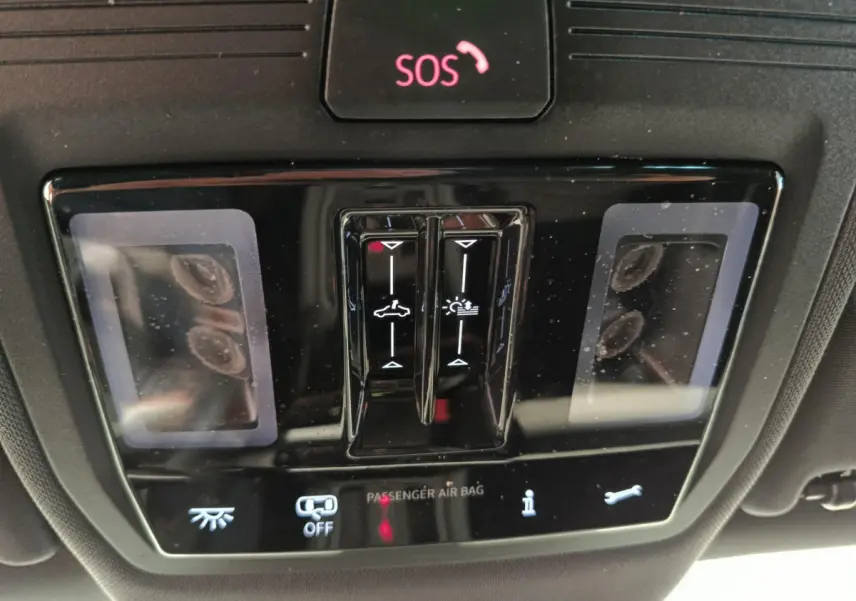 Vue rapprochée du panneau de commande intérieur noir avec bouton SOS et commandes d'éclairage de la CUPRA LEON ST 2024.