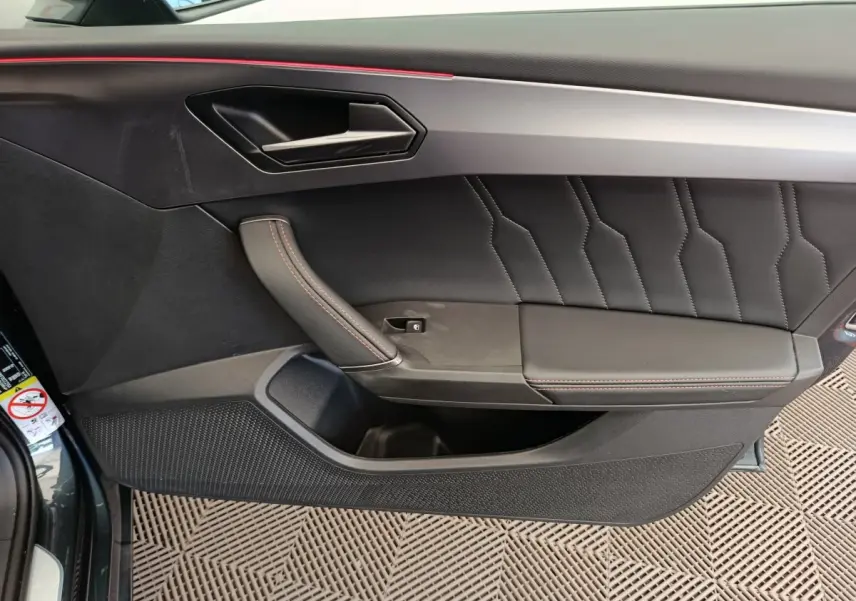 Panneau de porte côté gauche en cuir noir avec surpiqûres rouges du CUPRA LEON ST 2024 gris foncé.