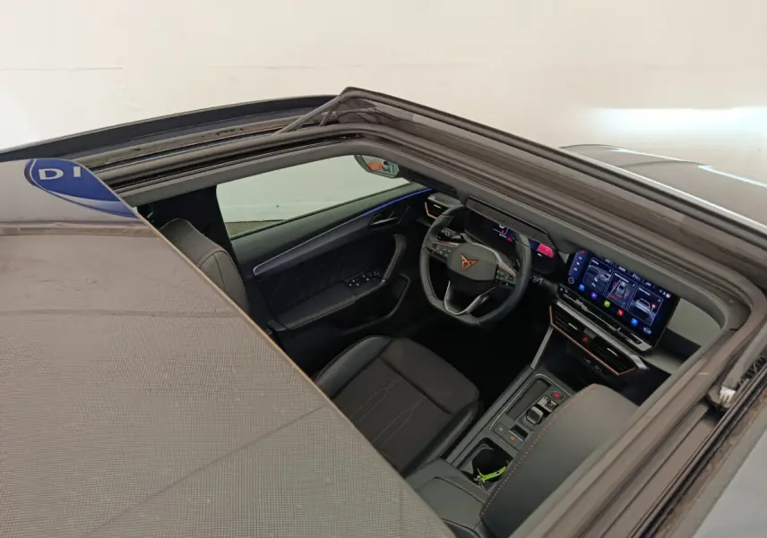 Vue intérieure côté conducteur de la CUPRA LEON ST gris foncé, avec tableau de bord digital et volant multifonctions.