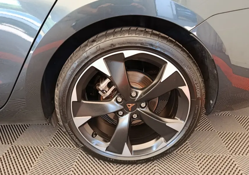 Gros plan sur la roue avant droite gris foncé de la CUPRA LEON ST 1.5 eTSI avec jante noire et argentée au logo CUPRA.