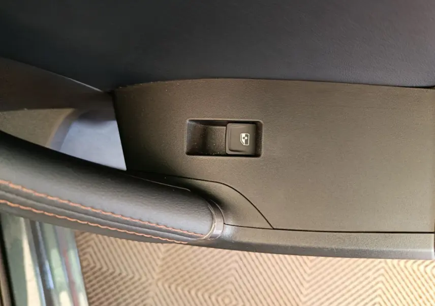 Gros plan sur le bouton de commande de vitre électrique sur la porte côté conducteur d'une CUPRA LEON ST gris foncé 2024.