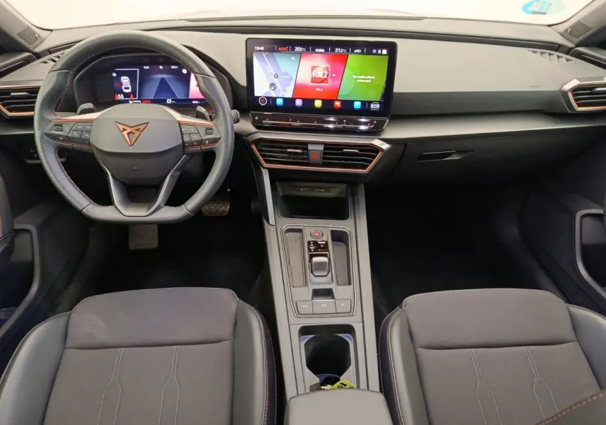 Intérieur de la CUPRA LEON ST 2024, vue frontale du tableau de bord avec écran tactile central et volant cuir noir.