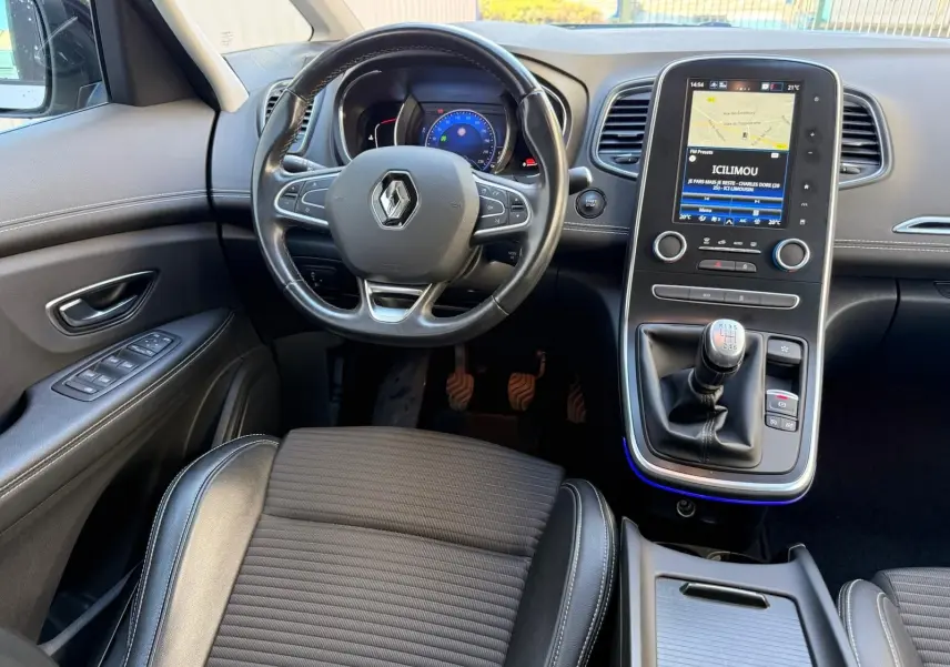 Vue intérieure avant du Renault Scenic IV 1.7 Blue dCi avec volant, tableau de bord numérique et levier de vitesse manuel.
