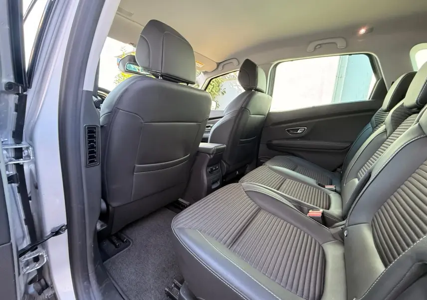 Vue intérieure arrière du Renault Scenic IV 2020 gris platine, montrant les sièges noirs et l'espace aux jambes côté droit.