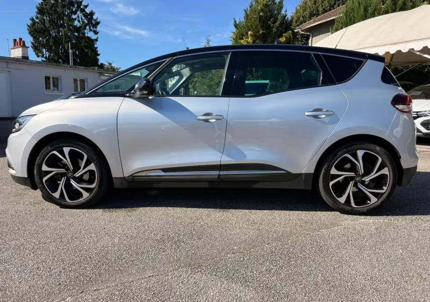 Profil côté gauche d'un Renault Scénic IV gris platine avec toit noir étoile et jantes alliage distinctives.