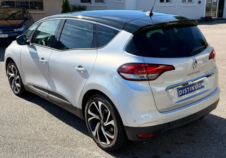 Vue 3/4 arrière droite du Renault Scénic IV gris platine avec toit noir étoile et jantes alliage distinctives.