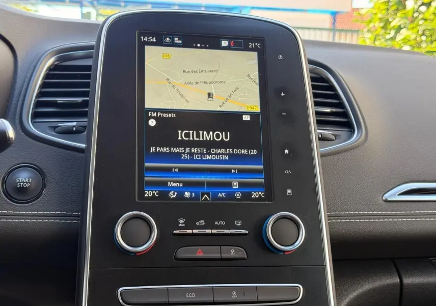 Tableau de bord du Renault Scenic IV 2020, avec écran tactile central affichant la navigation et la radio, ambiance intérieure noire.